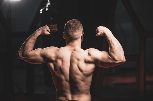 a man flexing his muscles in a gym
