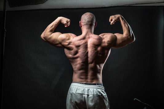 a man flexing his muscles in front of a black background
