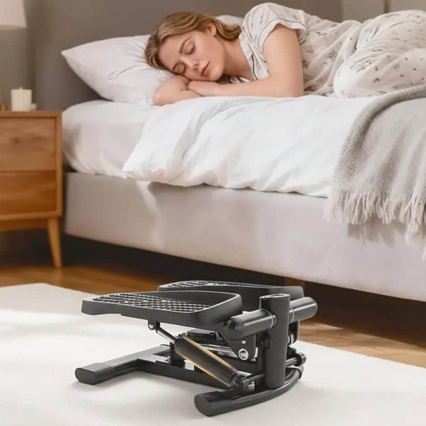 Stepper fitness compact pour un entraînement à domicile, à côté d'une femme dormant sur son lit.